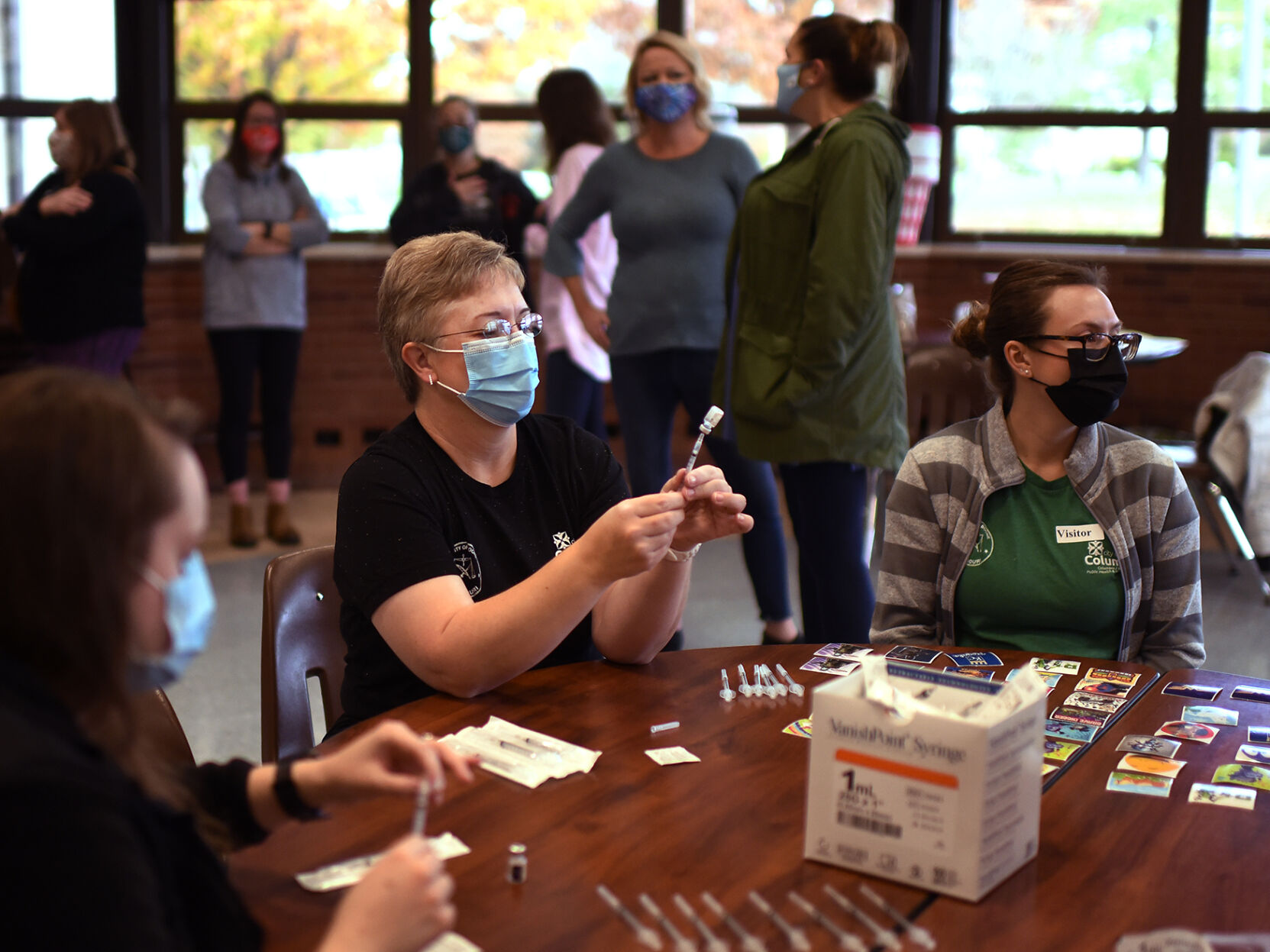 Susan Leach prepares a syringe at a vaccine clinic